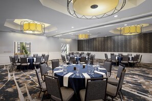 A conference room with round tables, chairs, and chandeliers. - DoubleTree by Hilton Philadelphia Center City (Philadelphia)