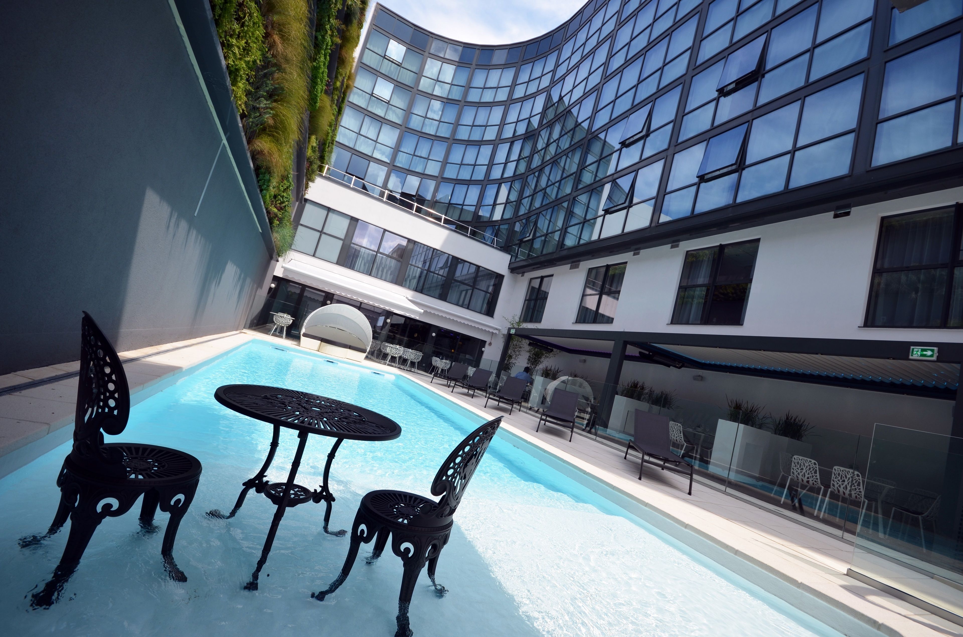 Una piscina al aire libre, sillones reclinables de piscina