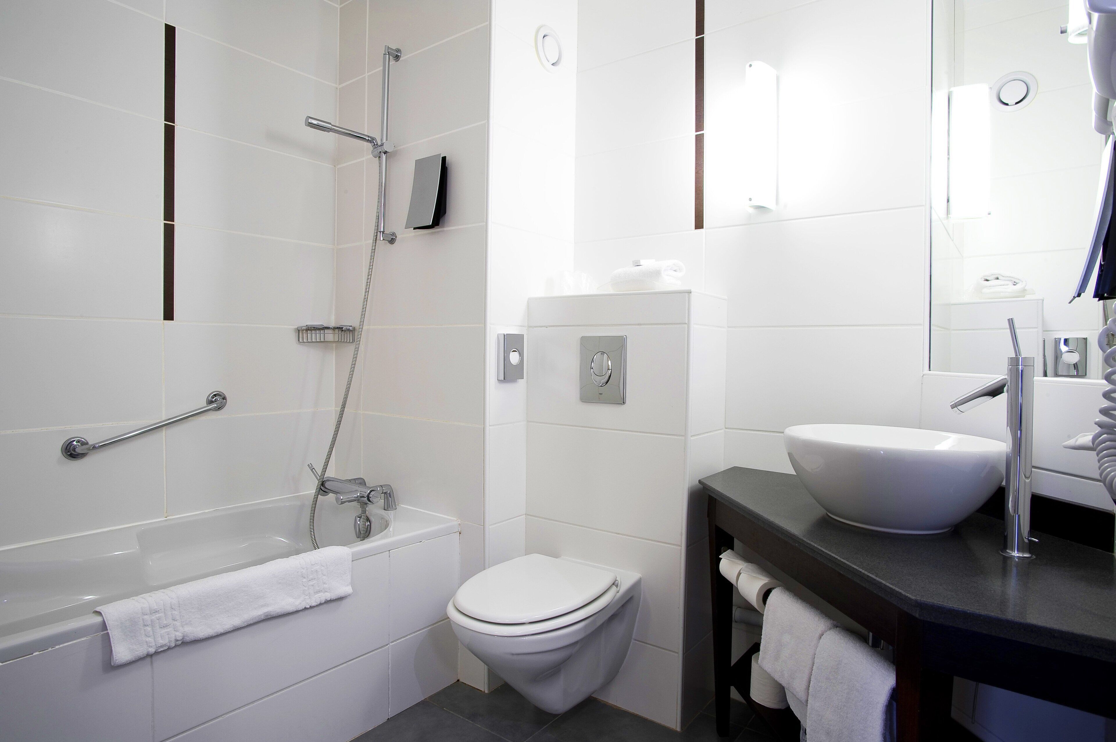 Ein modernes Badezimmer mit Badewanne, Toilette und Waschbecken.