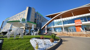Un hôtel Holiday Inn doté d’une façade moderne en verre et d’une grande sculpture extérieure.