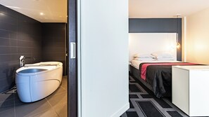 A modern bathroom with a freestanding bathtub and a separate toilet.
