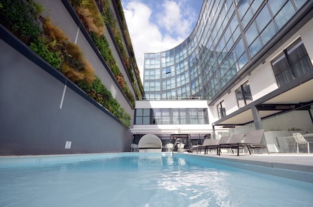 Una piscina al aire libre, sillones reclinables de piscina. Holiday Inn Dijon by IHG