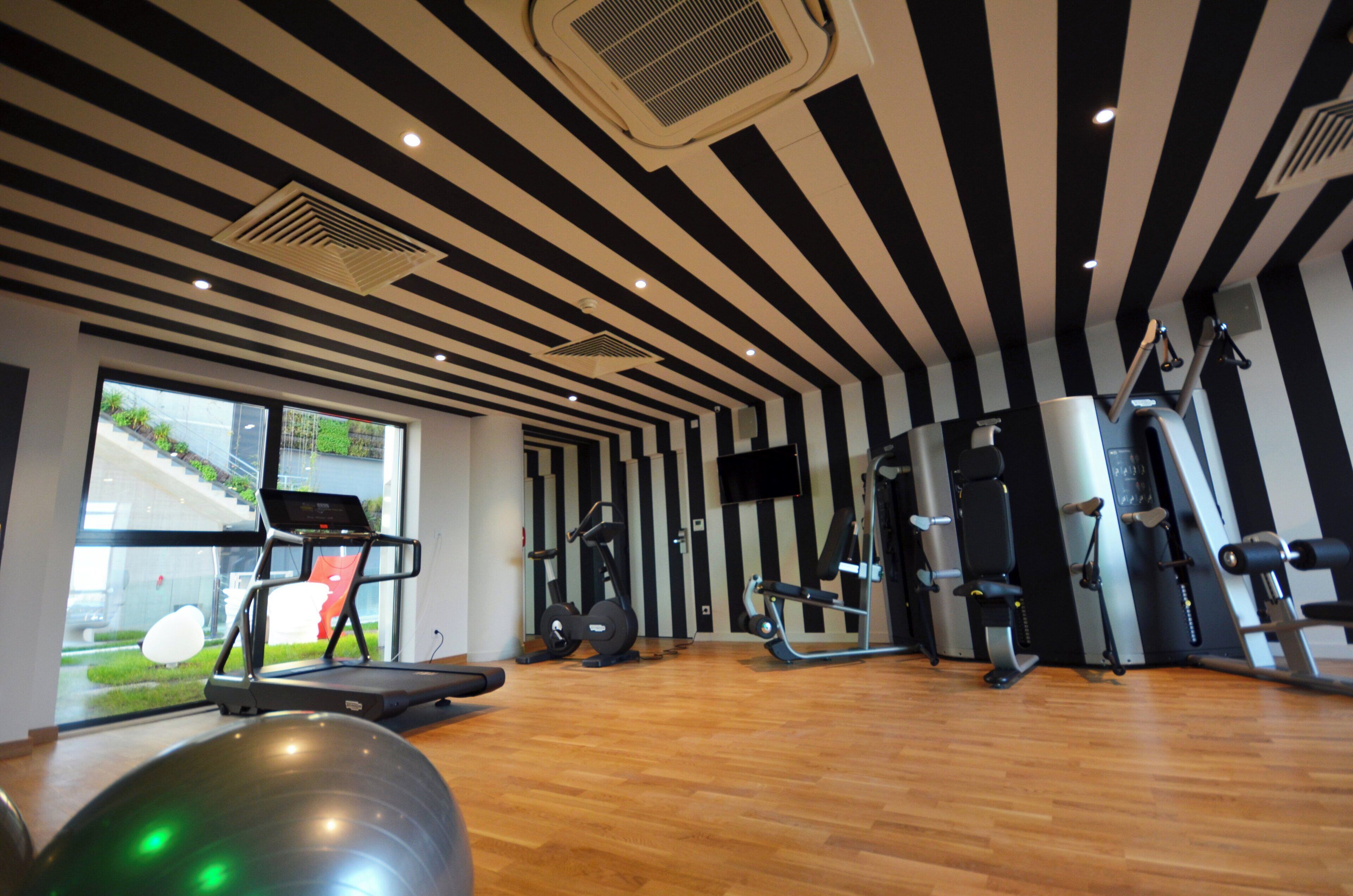 A gym with exercise equipment, a treadmill, and a large window.