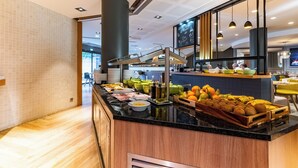 Un espace buffet proposant divers plats et une station où l’on peut se servir du café.