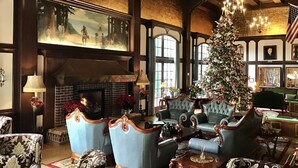 A traditional room with a fireplace, a large Christmas tree, and classic furniture. - Eureka Inn, Trademark Collection by Wyndham (Eureka)