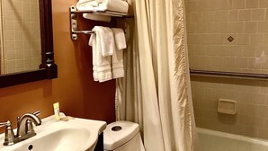 A bathroom with a sink, toilet, and shower area.