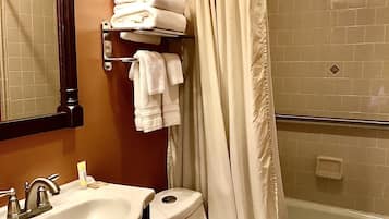 Un baño con lavamanos, inodoro y zona de ducha.