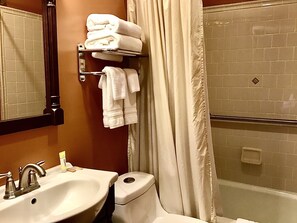 A bathroom with a sink, toilet, and shower area.