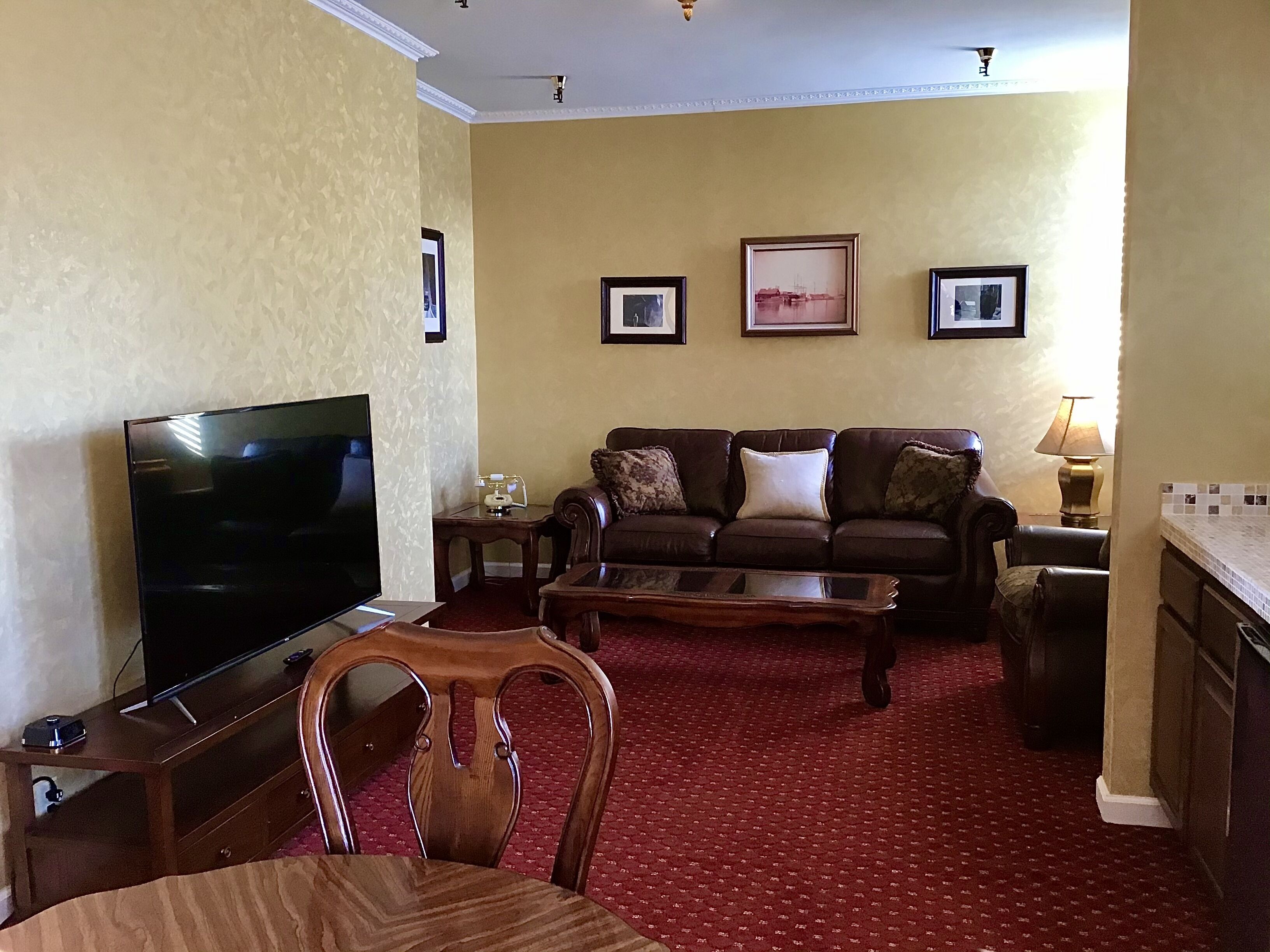 A living room with a TV, a sofa, a coffee table, and a patterned carpet.