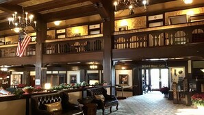 A lobby with a high ceiling, chandeliers, a reception desk, and a sign for the Bristol Rose Cafe. - Eureka Inn, Trademark Collection by Wyndham (Eureka)
