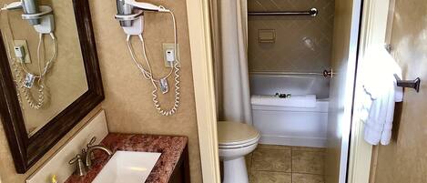A bathroom with a sink, mirror, and towel rack.