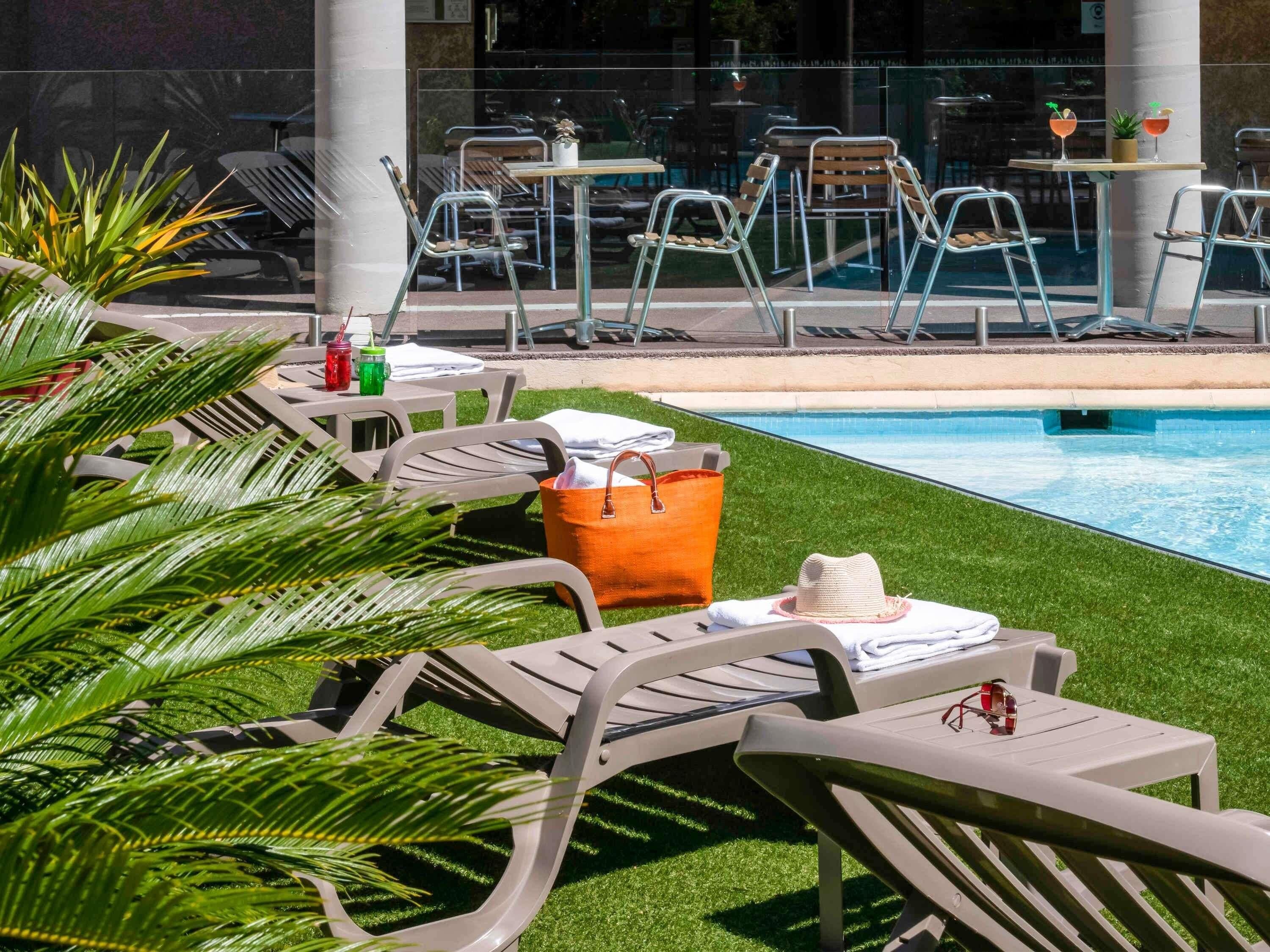 Una piscina al aire libre de temporada, sillones reclinables de piscina