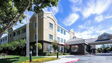 Classic hotel with a central entrance and beautifully manicured gardens.