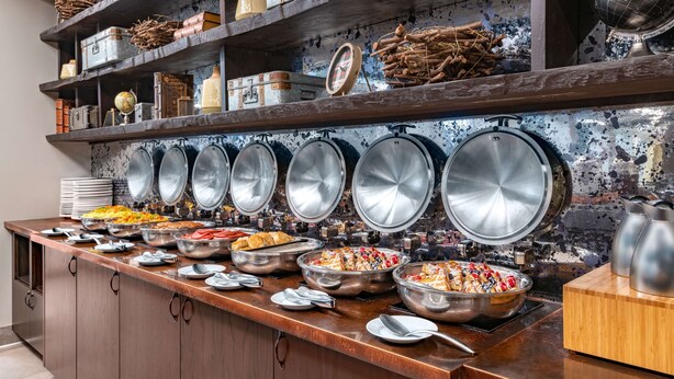 Un bufé con diversos alimentos y utensilios de cocina.