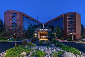 A DoubleTree by Hilton hotel with a symmetrical facade, large windows, and a landscaped entrance area.