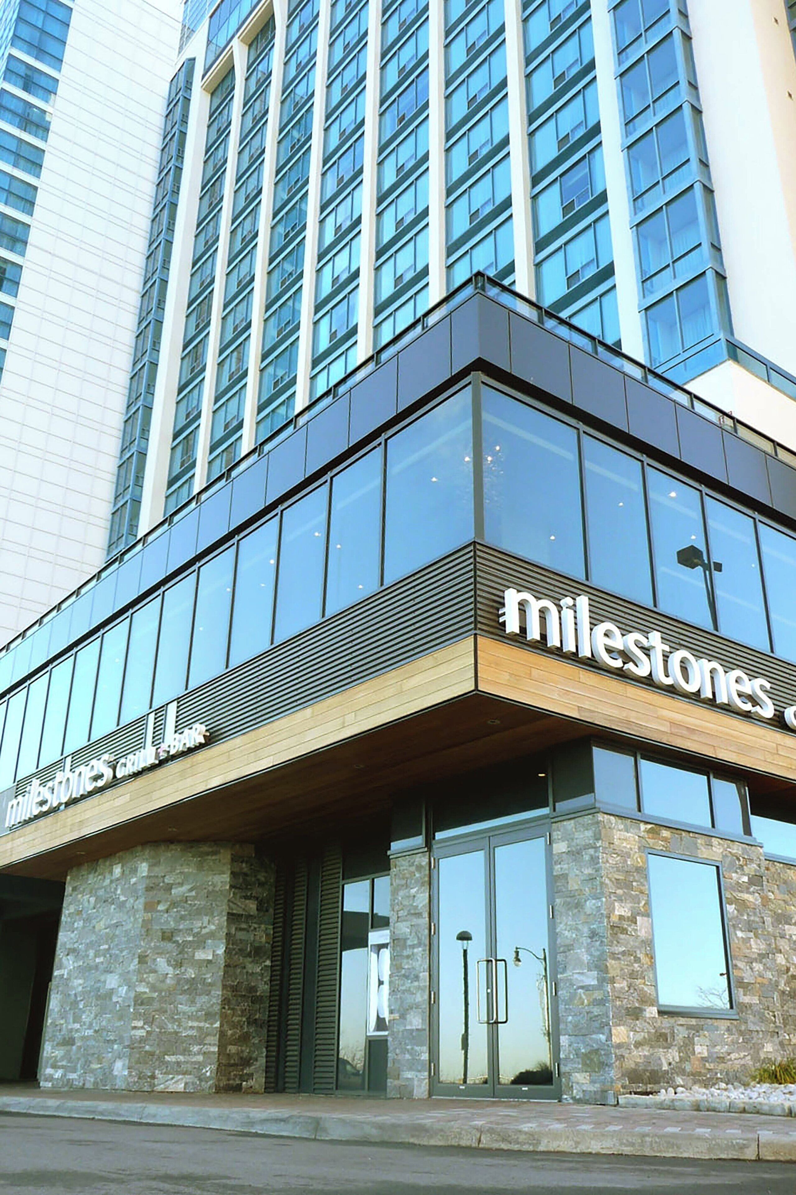 A modern building with a glass facade and the name "Milestones" on the ground floor.