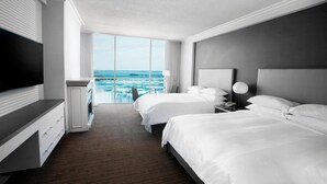 A hotel room with two beds, a TV, a desk, and a view of the ocean. - Niagara Falls Marriott on the Falls (Niagara Falls)