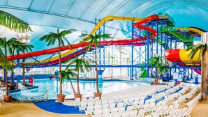 An indoor water park with a pool, water slides, and lounge chairs. - Niagara Falls Marriott on the Falls (Niagara Falls)