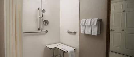 A modern bathroom with a shower, a small sink, and a mirror.