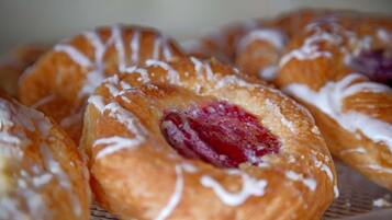 Primer plano de pasteles con glaseado y un relleno de fruta visible.
