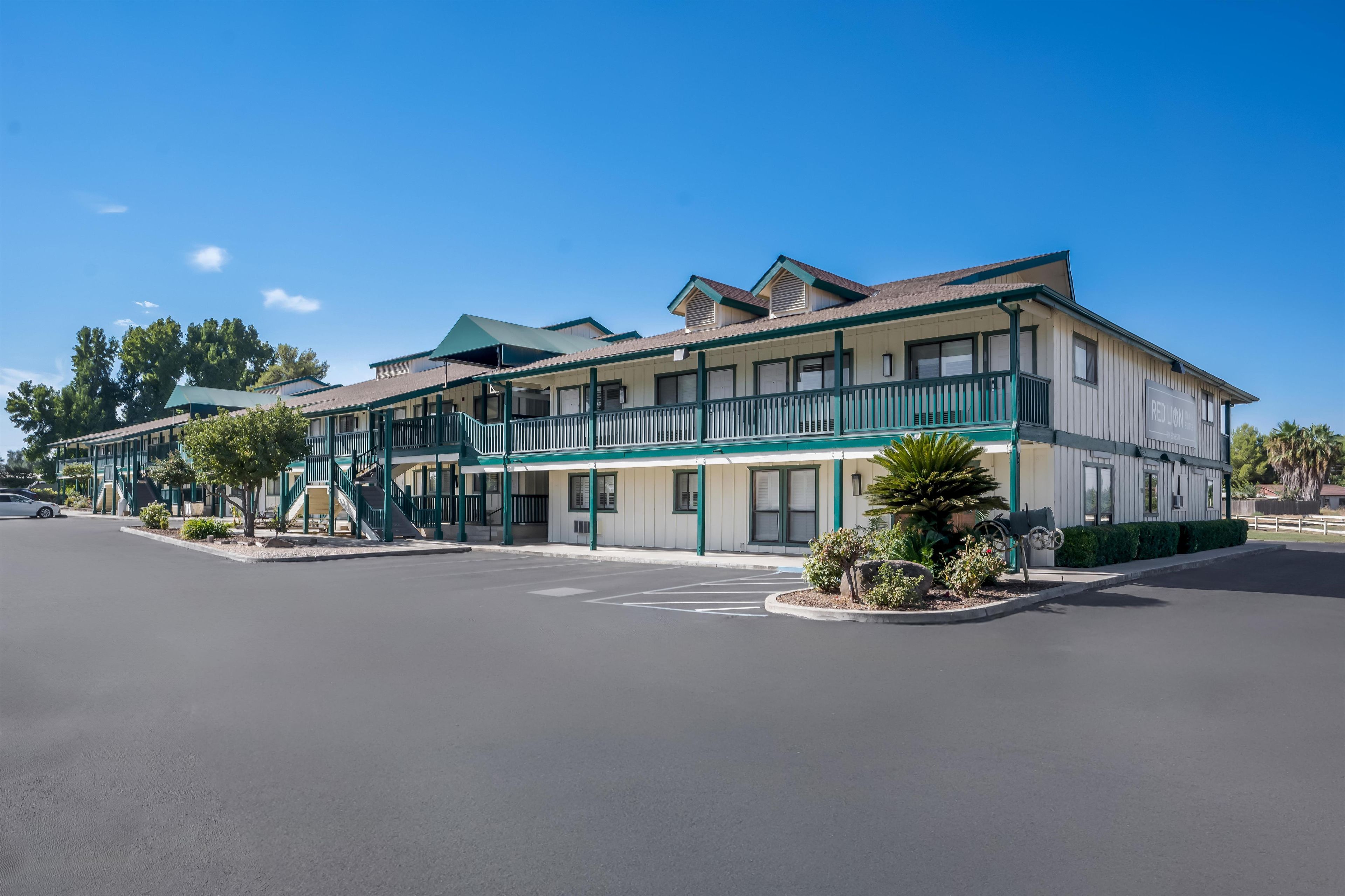 A two-story motel with a covered front porch and a parking lot.