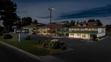Um hotel com vários andares e uma placa com a inscrição 'RED LION INN & SUITES BY SONETA'.