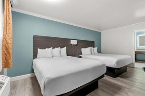 Une chambre d’hôtel avec deux lits, un climatiseur fixé au mur et une fenêtre donnant sur un paysage agréable.