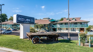 Un Red Lion Inn & Suites by Sonesta con un edificio de dos pisos, una zona de estacionamiento techada y un cartel.