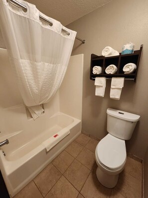 Een bad/douchecombinatie, een haardroger, handdoeken