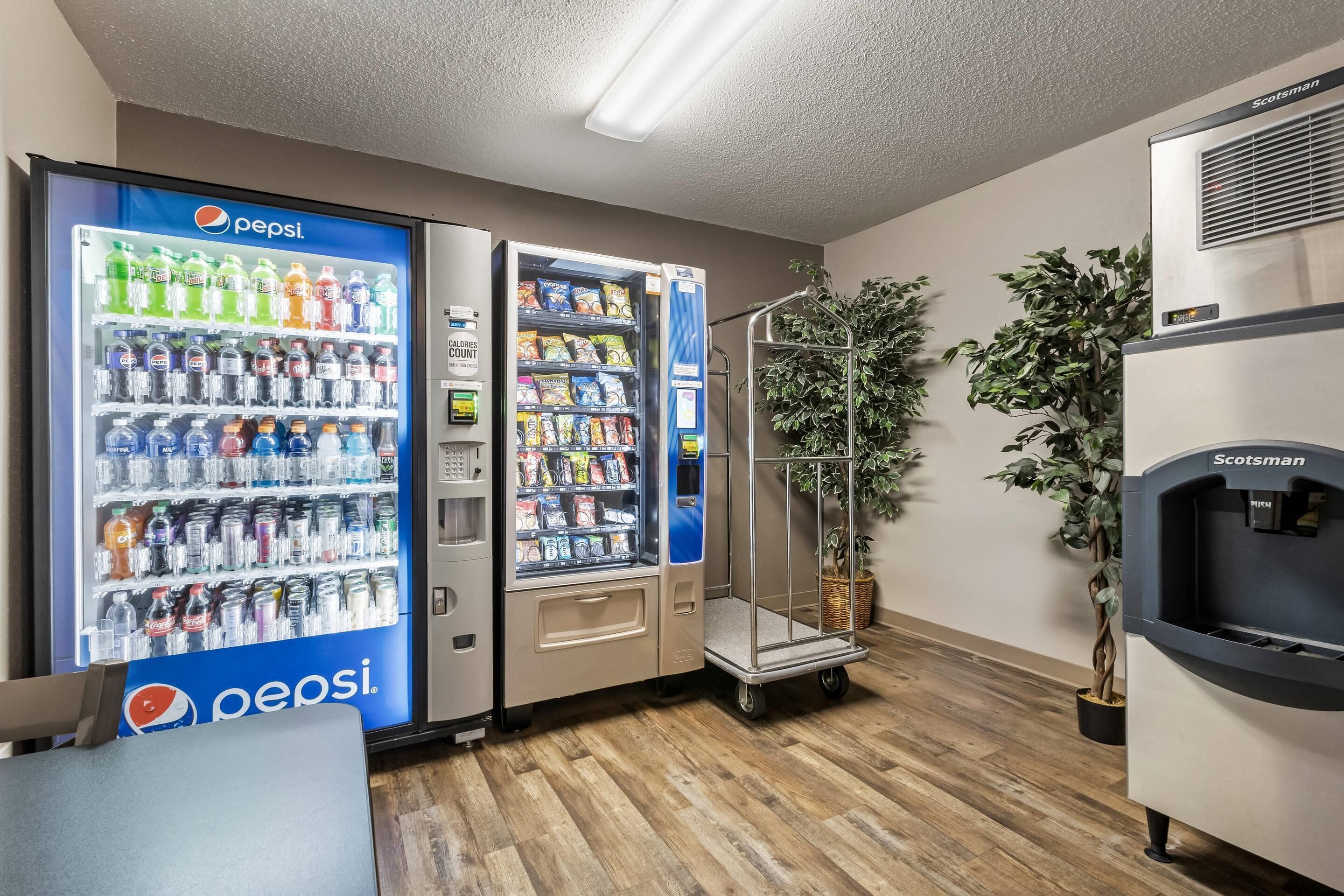 A room with a Pepsi refrigerator, a water dispenser, and a vending machine.