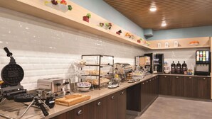 A modern kitchen with a waffle maker, toaster, and various food items on the counter. - Country Inn & Suites by Radisson, La Crosse, WI (La Crosse)