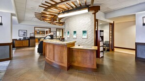A modern kitchen with a central island, wooden ceiling design, and a brick accent wall. - Hyatt Place Columbus/Worthington (Columbus)