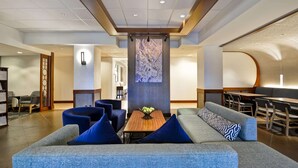 A modern lobby with a sofa, chairs, a coffee table, and a wall-mounted artwork. - Hyatt Place Columbus/Worthington (Columbus)