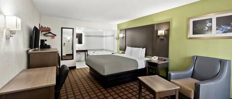 A hotel room with a bed, desk, chair, and a small table.