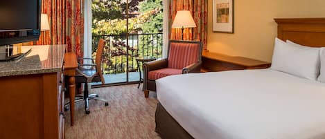 Ein Hotelzimmer mit Bett, Schreibtisch, Stuhl und Blick ins Freie.