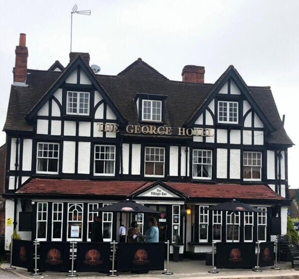 Un edificio de estilo Tudor tradicional con un letrero que dice 'The George Hotel'.