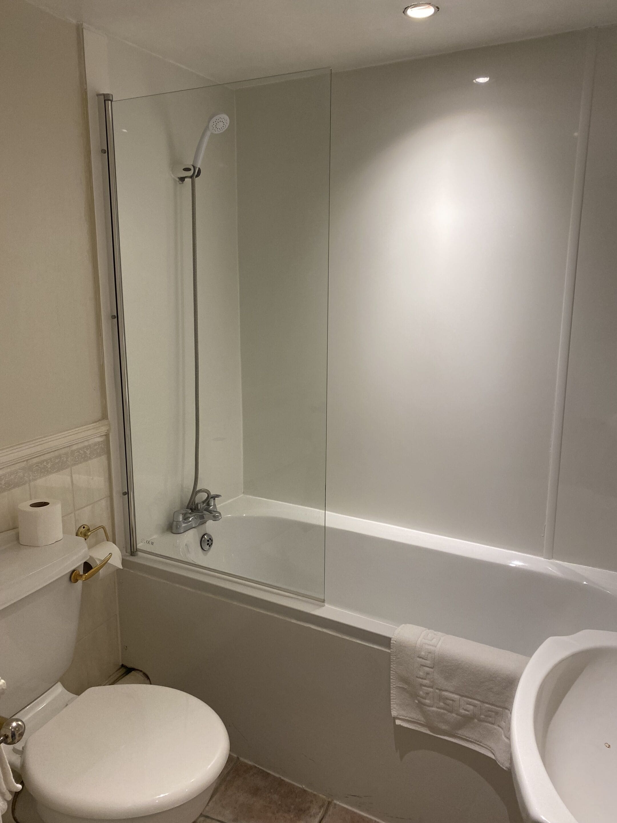 Un baño con inodoro, lavamanos, bañera y ducha.