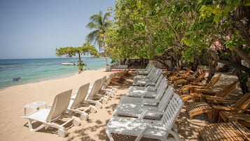 Trên bãi biển, cát trắng, ghế dài tắm nắng, khăn tắm biển