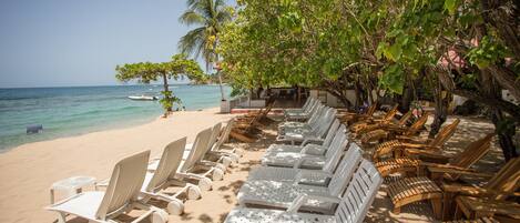 Am Strand, weißer Sandstrand, Liegestühle, Strandtücher