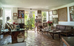 A spacious living room with a large window, a dining area, and a sofa.
