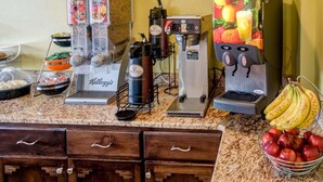 Un espace dédié au café, équipé de plusieurs machines à café, avec un panier de fruits et une corbeille de bananes.