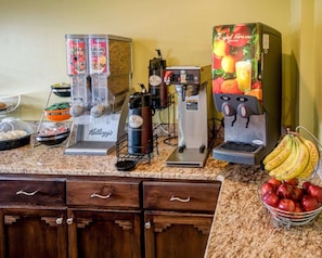 Un espace dédié au café, équipé de plusieurs machines à café, avec un panier de fruits et une corbeille de bananes.