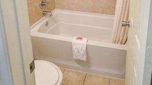 Une salle de bain avec une baignoire, des toilettes et un porte-serviettes.