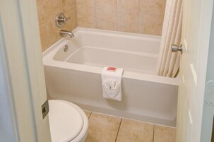 Un baño con bañera, inodoro y toallero.