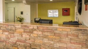 A reception area with a stone counter, a reception desk, a sign for 'Concord Lodge,' and a door in the background. - Econo Lodge Albuquerque East (Albuquerque)