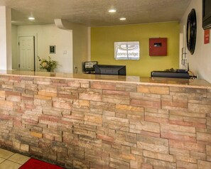 A reception area with a stone counter, a reception desk, a sign for 'Concord Lodge,' and a door in the background. - Econo Lodge Albuquerque East (Albuquerque)