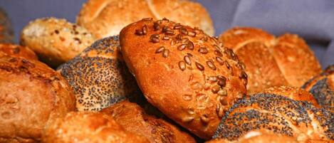 A variety of breads with seeds on a cloth.
