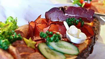 A charcuterie board with various meats, cheese, and vegetables.