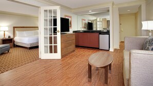 Une chambre d’hôtel comprenant un lit, une petite table, un canapé, une kitchenette et une salle de bain.