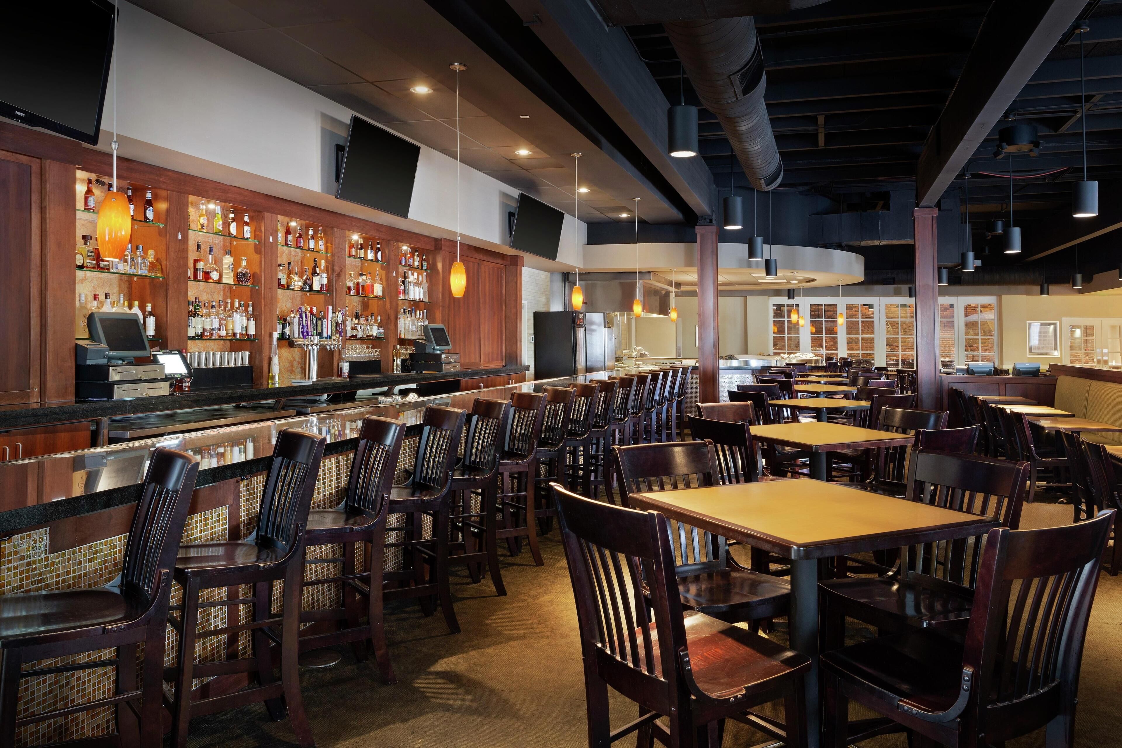 A restaurant with a bar area, multiple seating options, and a modern interior design.